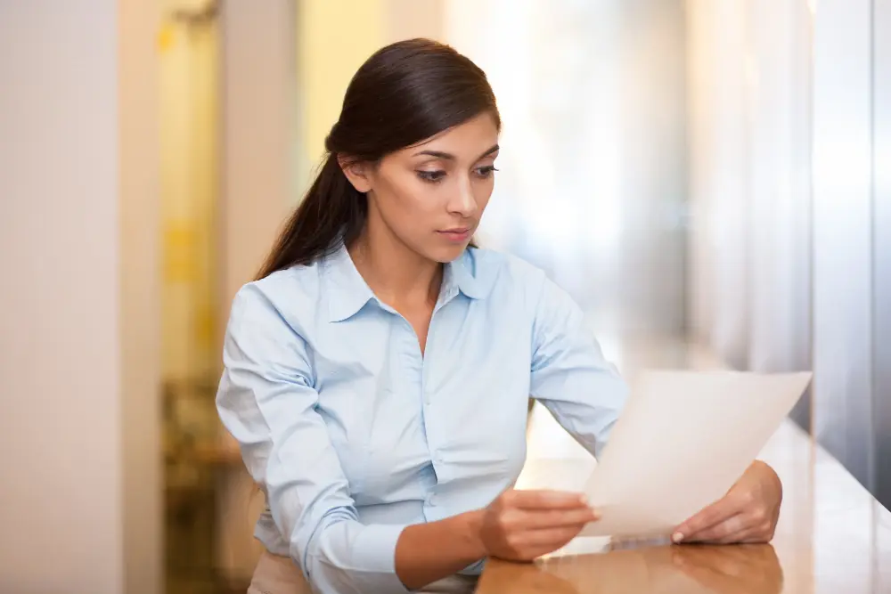 Young female OnlyFans creator sitting down and reading an HMRC nudge letter.