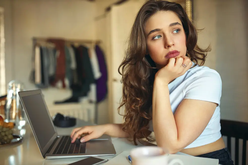 OnlyFans creator looking worried at a desk while doing a Self Assessment tax return.